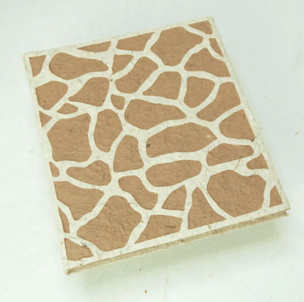 Image of a journal made out of poo with giraffe print on the front