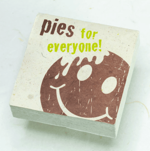 Image of paper scratch pad made out of poo with pies for everyone written on the front